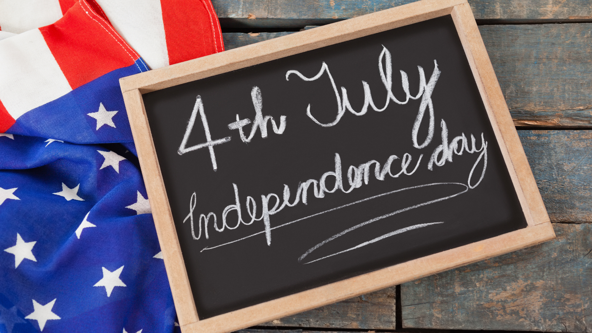 Close-up of American flag and slate with text 4th july independence day